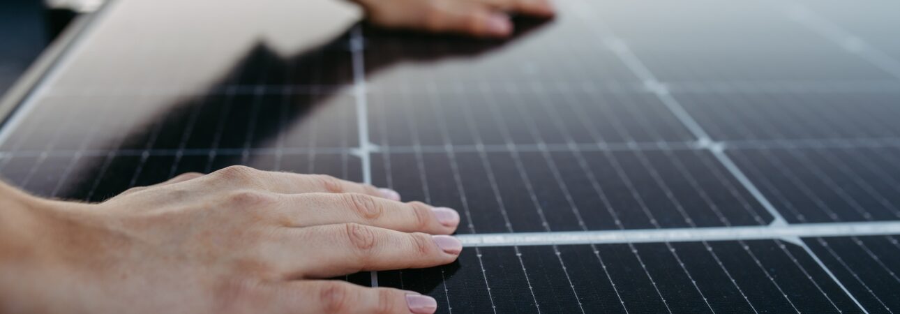Close up of woman touching solar panels on the roof.